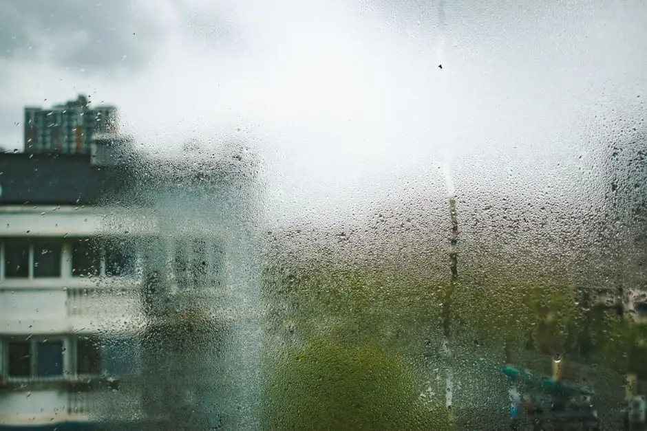 View of Shanghai buildings through a dewy, moisture-covered window during a cloudy day.